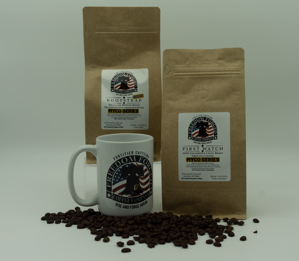 Two brown coffee bags and a white mug with coffee beans on a light gray background